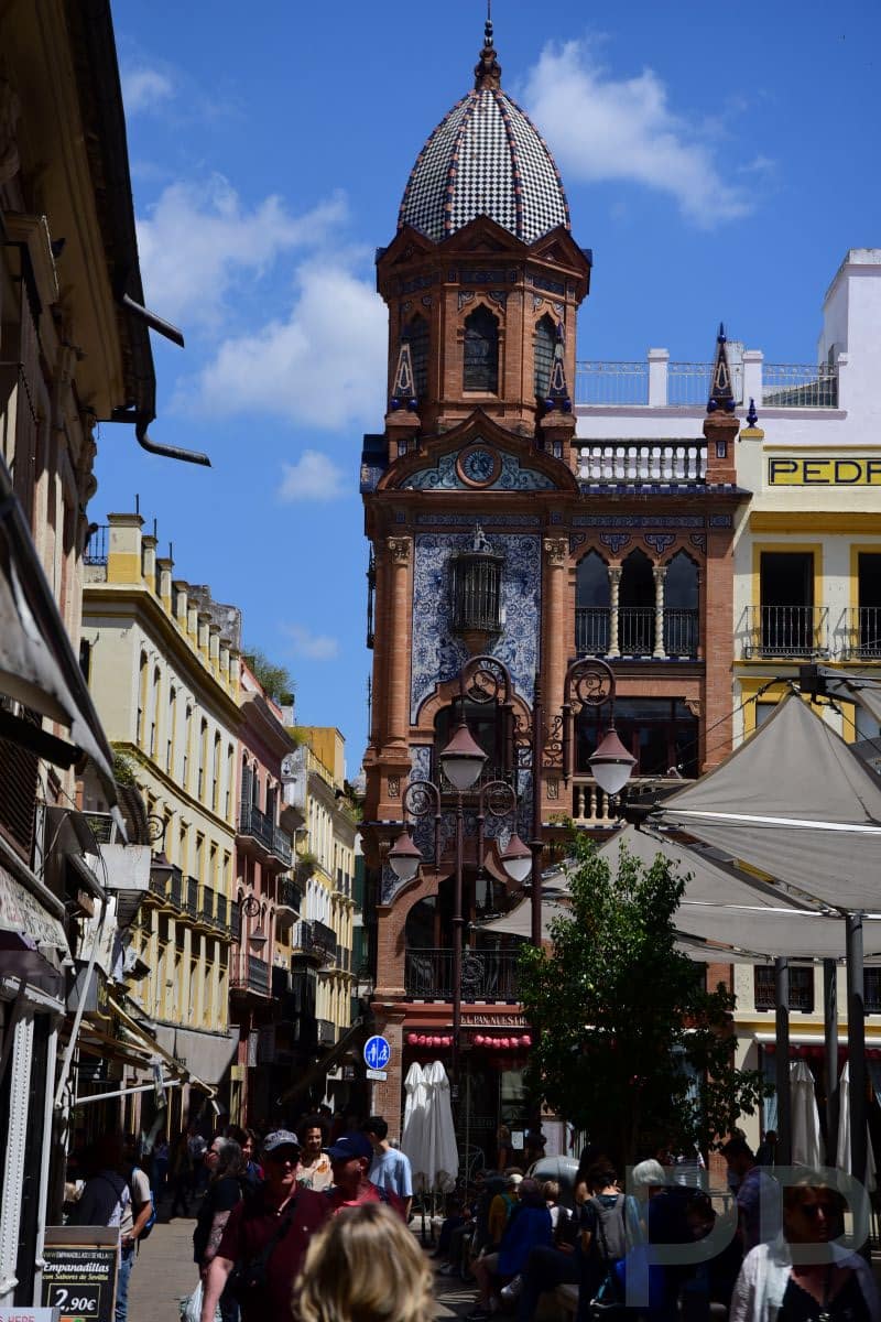 Pedestrian shopping street in Seville with storefronts and people
