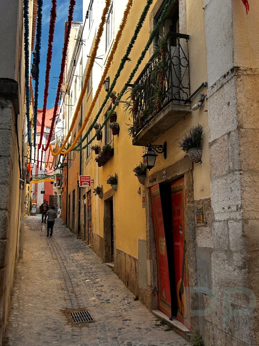 Narrow cobblestone street in Alfama, Lisbon&rsquo;s oldest neighborhood.