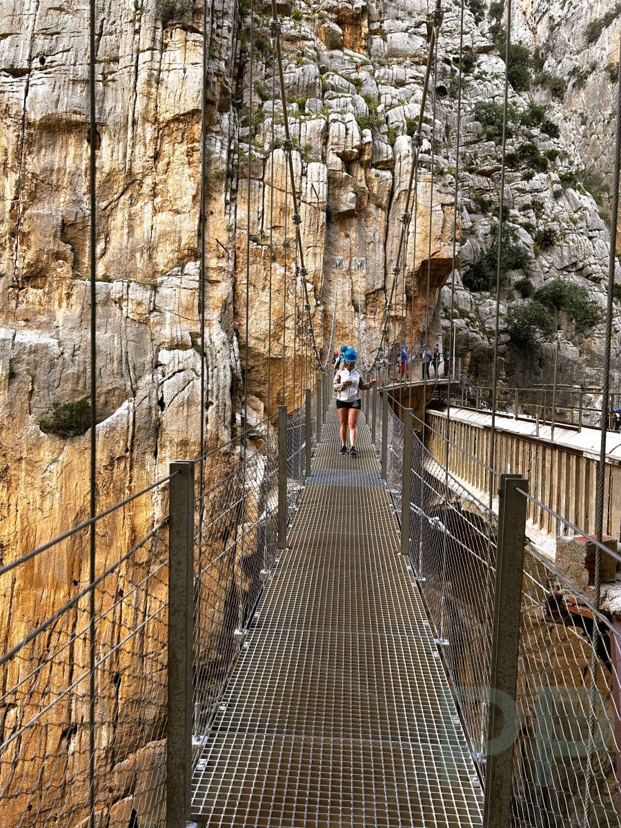 Hikers crossing the suspension bridge along the Caminito del Rey trail.
