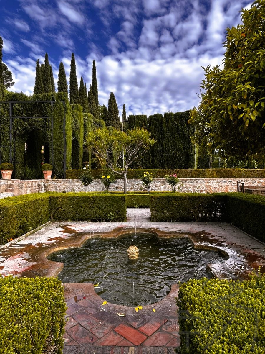 Generalife Gardens at the Alhambra with fountains, greenery, and formal pathways.